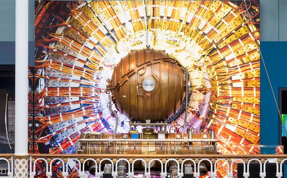 A large spherical copper cavity on display in a museum gallery.