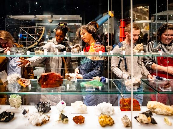 Five visitors looking at shelves of a different coloured agates.