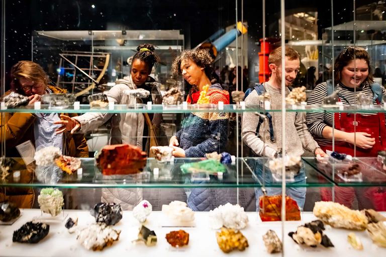 Five visitors looking at shelves of a different coloured agates.