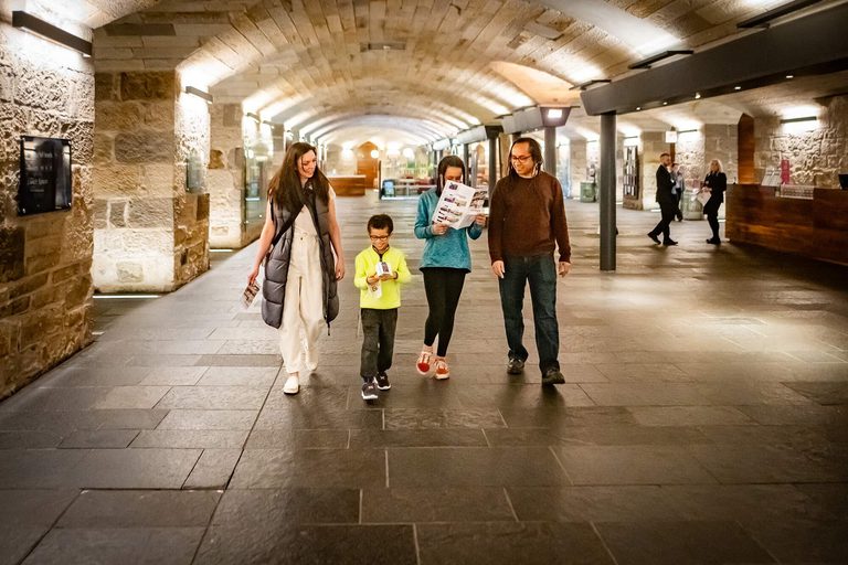 A family of four walk through a museum entrance hall with a low arched roof.