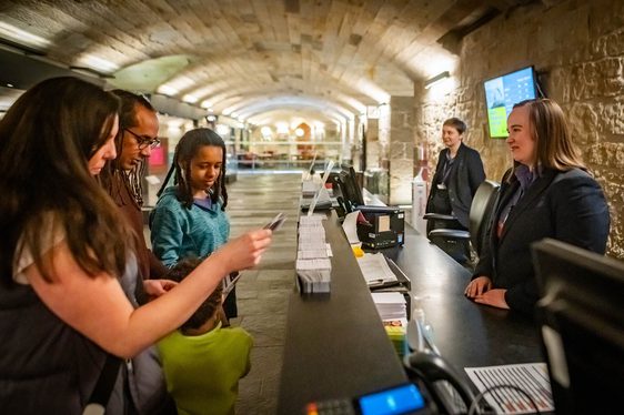Visitors looking at a map at a museum information desk.