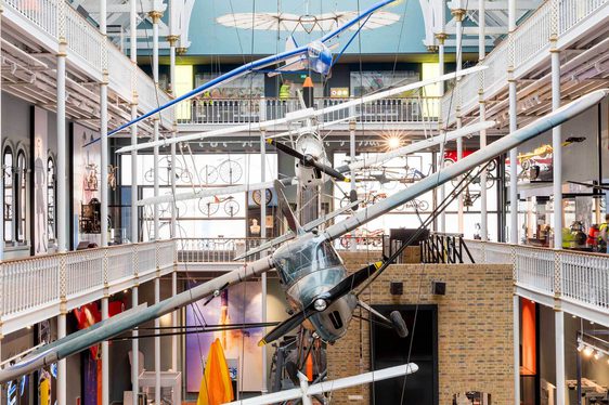 Aircraft hanging from the ceiling of a multi-storey museum gallery.