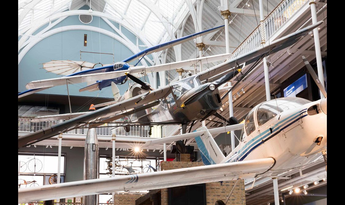 Four types of aircraft hanging from the ceiling of a large museum gallery