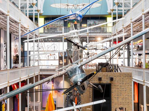 Aircraft hanging from the ceiling of a multi-storey museum gallery.