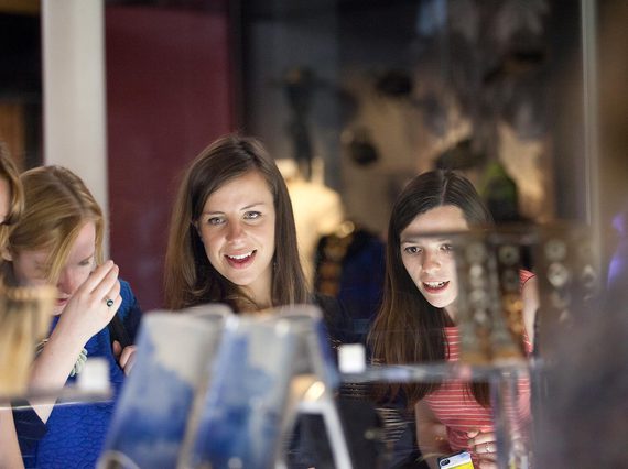 Four visitors look through a display case in the Fashion and Style gallery.