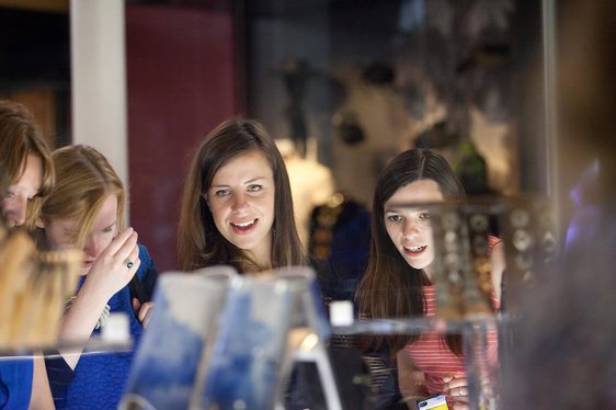 Four visitors look through a display case in the Fashion and Style gallery.
