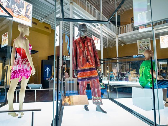 Three mannequins dressed in fashionable clothing: two standing in dynamic poses and one seated.