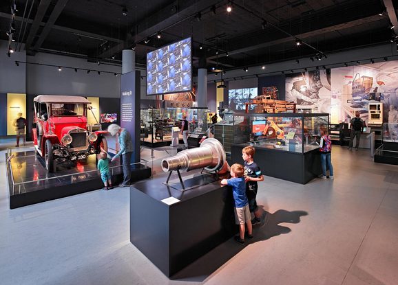 Young children interacting with different displays of technology in a museum gallery.