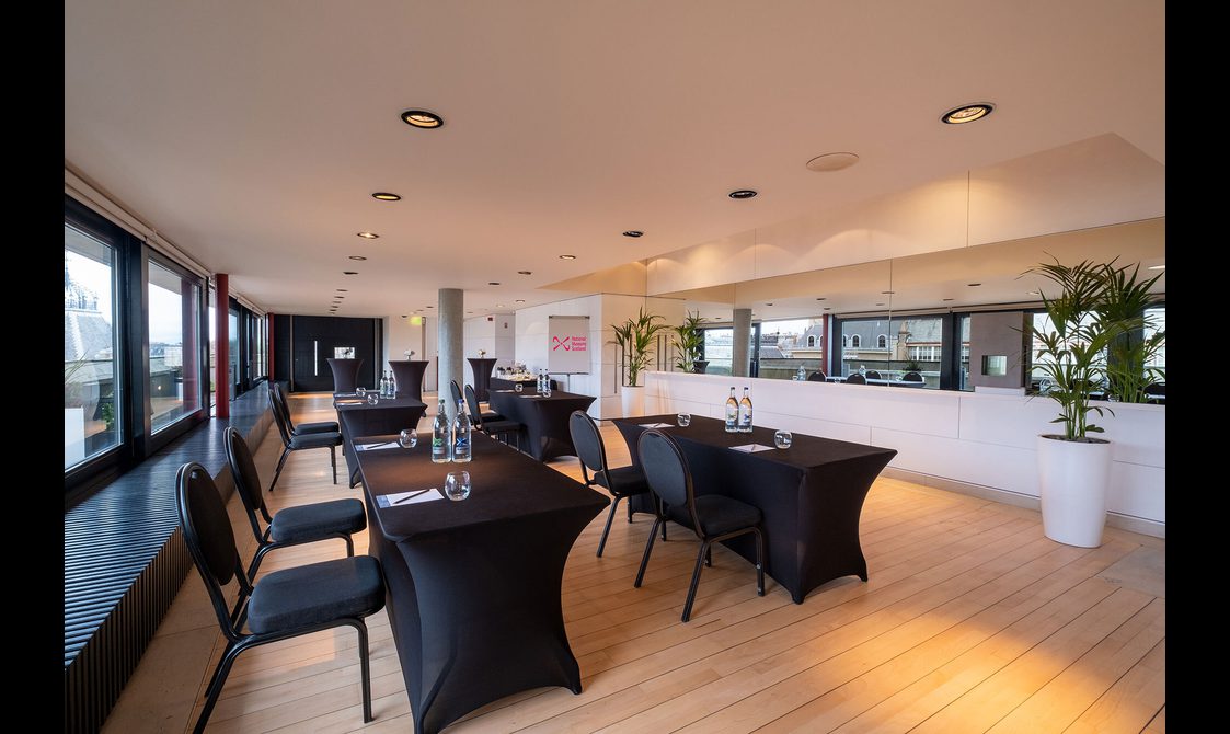 Tables set up for a meeting in a rooftop space.