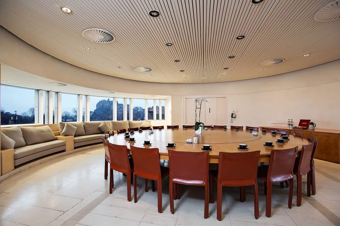 A circular board room with a large table set up for a meeting.