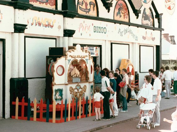 The outside of a seaside arcade with people lining up outside.