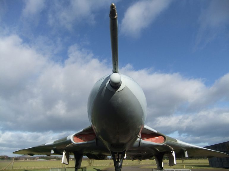 A close up view of the nose of an aircraft that is stationary on the ground.