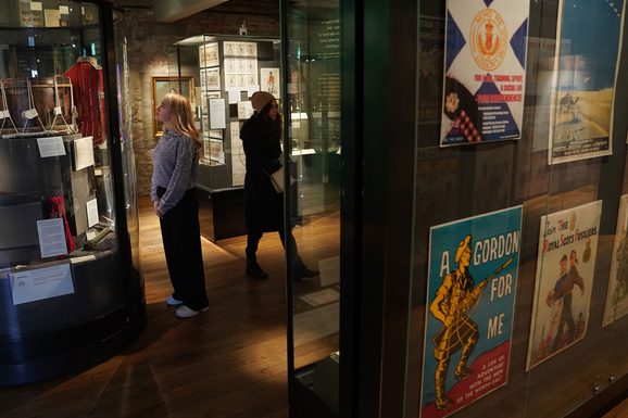 People looking at objects in glass museum cases