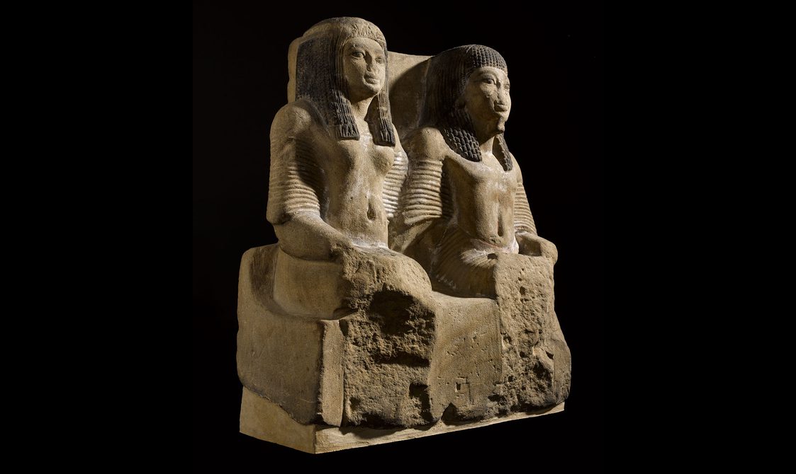 An Egyptian statue of a seated man and woman.