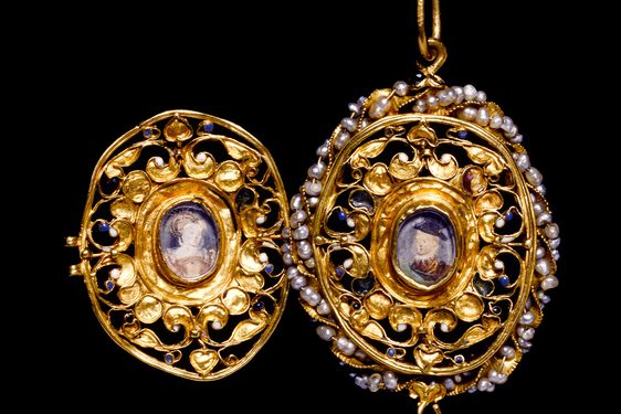 An elaborate gold locket with pearls around one of its edges. It is open to reveal a portrait of a woman and of a boy.
