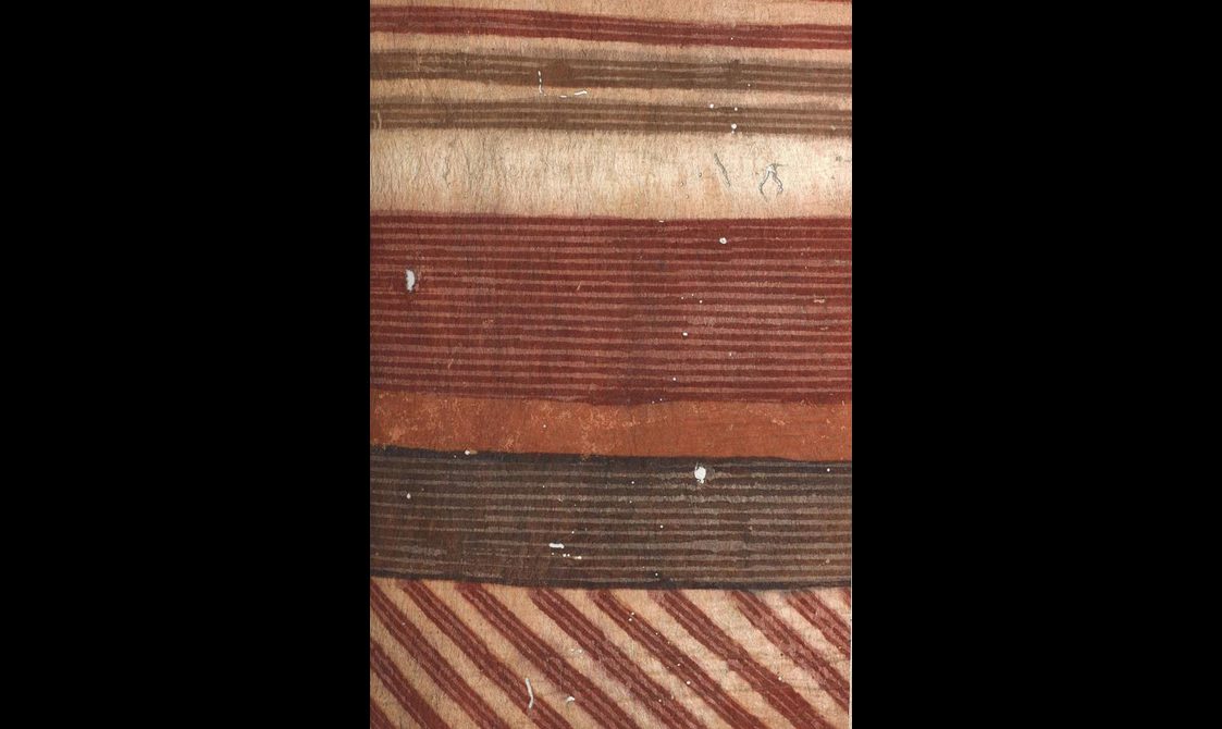 Yellow bark cloth with four horizontal striped patterns of red, black and orange colors. A diagonal striped pattern of red color positioned at the bottom.
