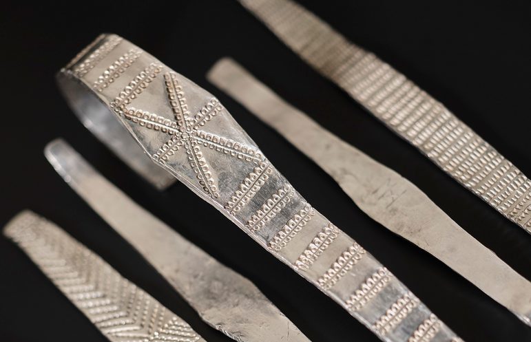 5 silver arm rings from the galloway hoard laid down side by side.