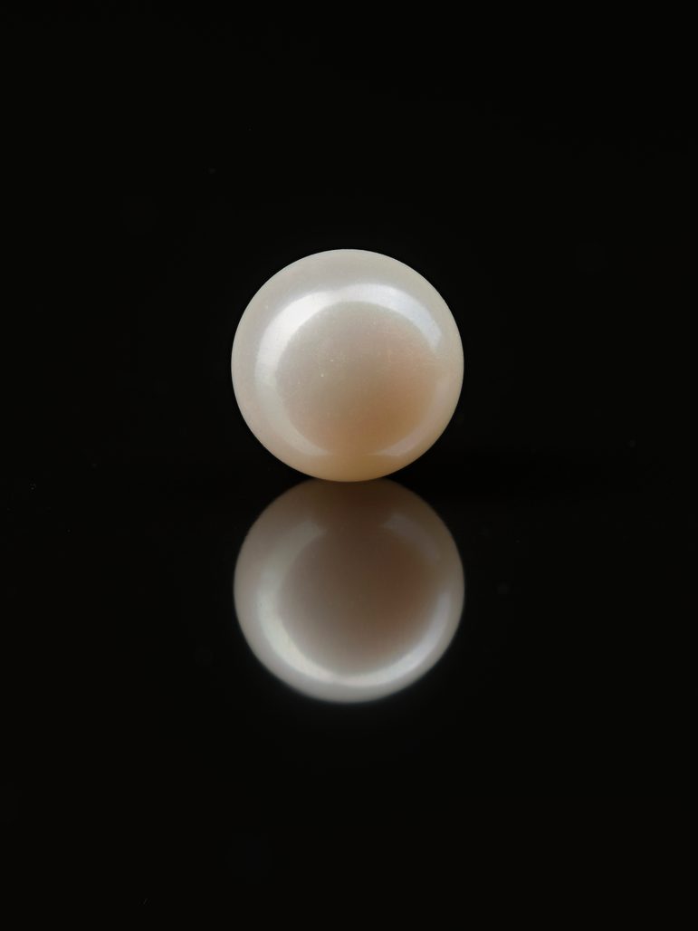 A large white luminious pearl against a black background.