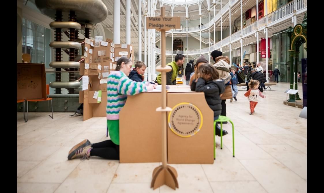 People are writing climate pledges at the national museum of scotland.