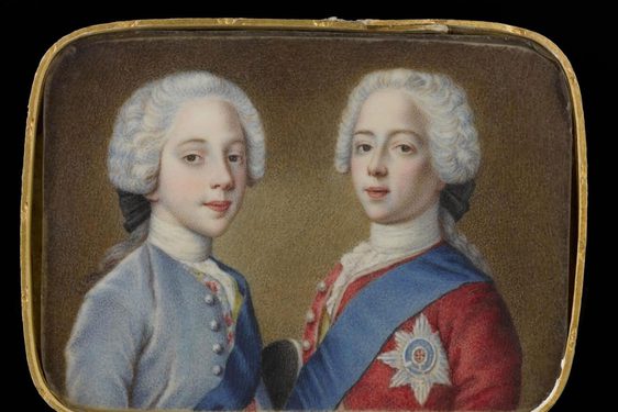 A portrait of two young men turned to one another sideways. The man on the left is wearing a white ruffle wig an a blue jacked with buttons. The man on the right is wearing a white ruffled wig and a red jacket with buttons, a blue ribbon draped over left shoulder and a six point star medal pinned to the coat.