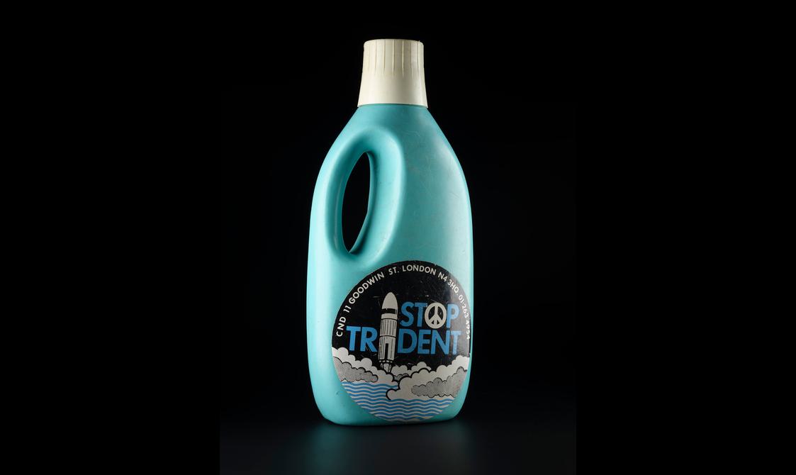 A blue laundry detergent bottle with a sticker reading "Stop Trident".