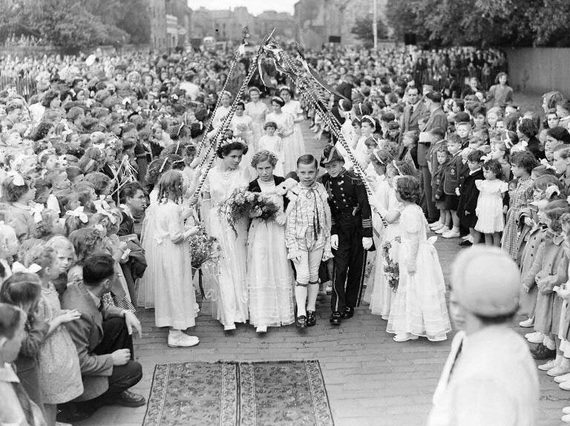 A gala day queen and her party made up of children walk through a crowd of hundreds of children