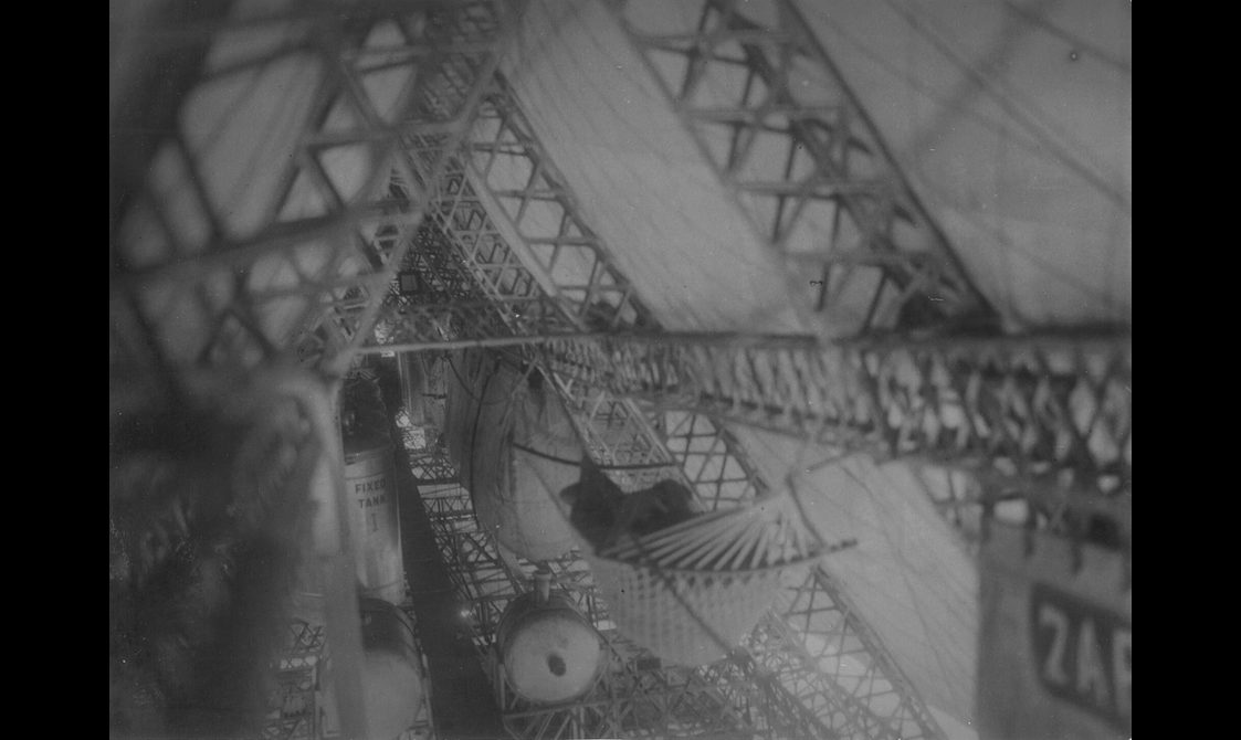 A black and white photograph of the interior of an airship showing structural frames and hammocks.