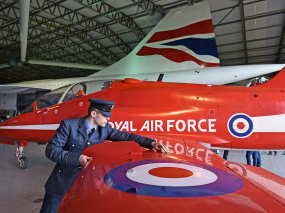 Pilot polishing the wing of a Red Arrows Hawk aircraft