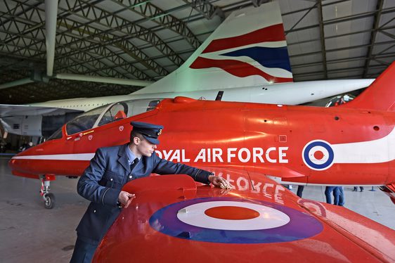 Pilot polishing the wing of a Red Arrows Hawk aircraft