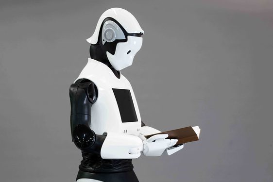 A white robot reading a book.