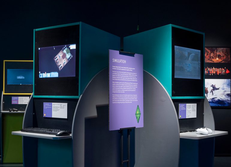 2 video game consoles at the Game On exhibition. A panel in the middle is titled 'simulation'.