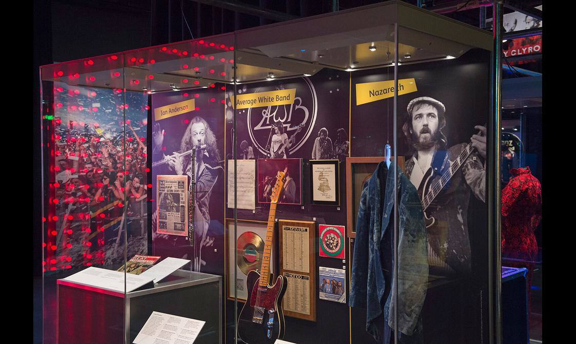 Objects relating to Scottish rock musicians on display in a museum exhibition.