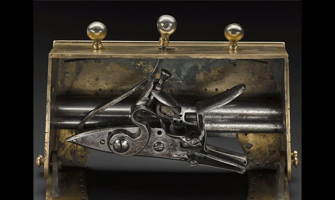 Close up of an open brass sporran clasp with hidden pistols inside.