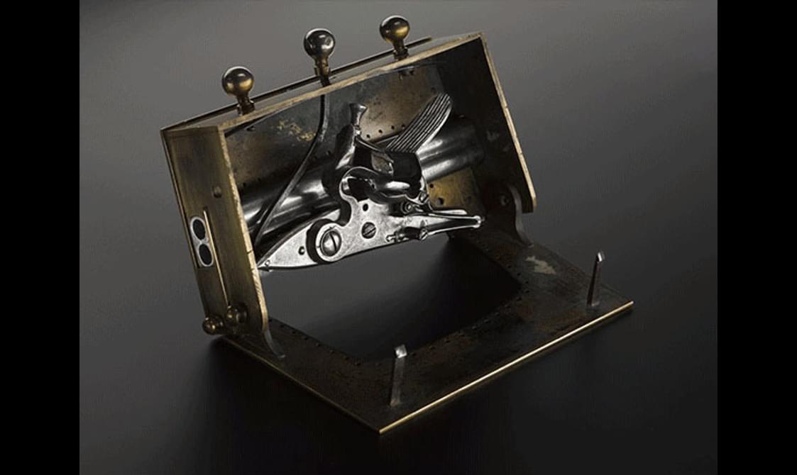 An open brass sporran clasp with hidden pistols inside.