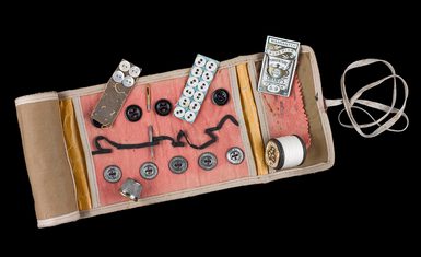 Small sewing kit with buttons, thread, needles and thimble.