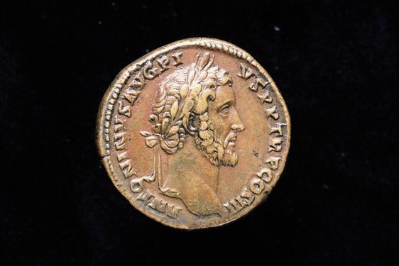 Rusted bronze coin depicting a man in profile with a thin chin-strap beard and curly hair.