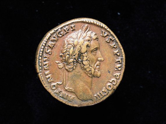 Rusted bronze coin depicting a man in profile with a thin chin-strap beard and curly hair.
