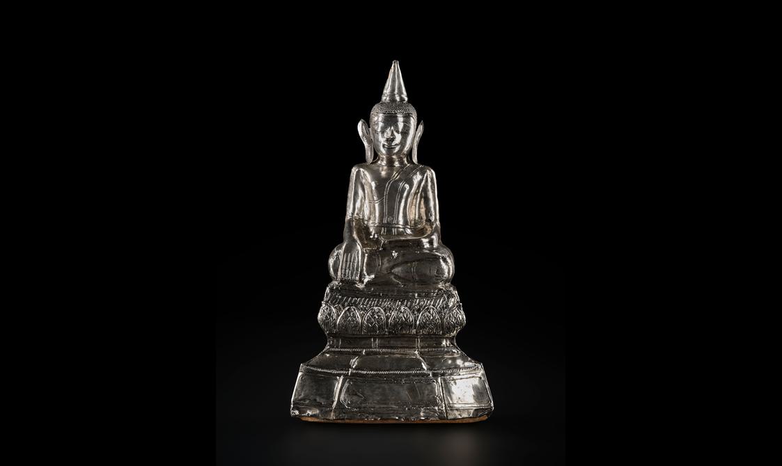 A silver Buddha sculpture.