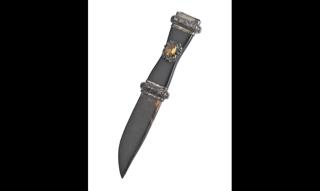 A sgian dubh with a yellow cairngorm on the wooden hilt.