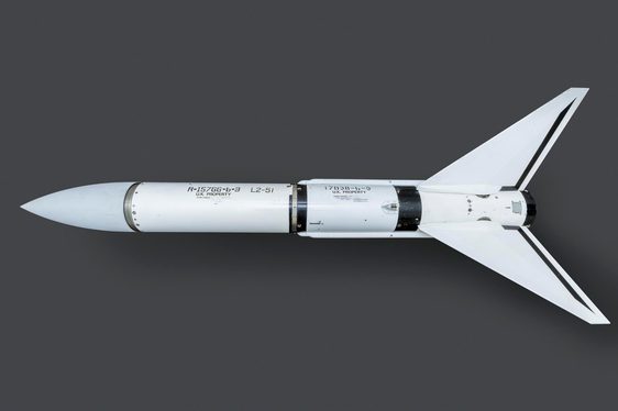 A white rocket-shaped missile on a grey surface.