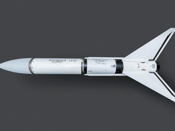 A white rocket-shaped missile on a grey surface.