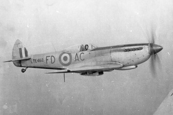 A black and white photograph of a pilot flying a spitfire aircraft.
