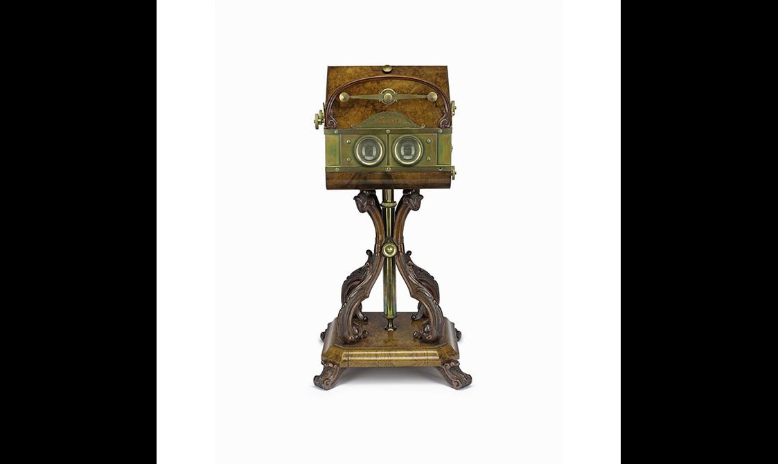 A wooden stereoviewer device on a stand with curved legs.