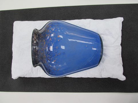 A blue vase lying on a conservation Tyvek® pillows.
