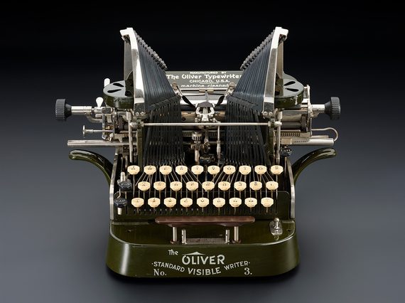Green mechanical typewriter from the early 1900s with white keys. It says 'The Oliver No. 3, Standard Visible Writer' on the front.
