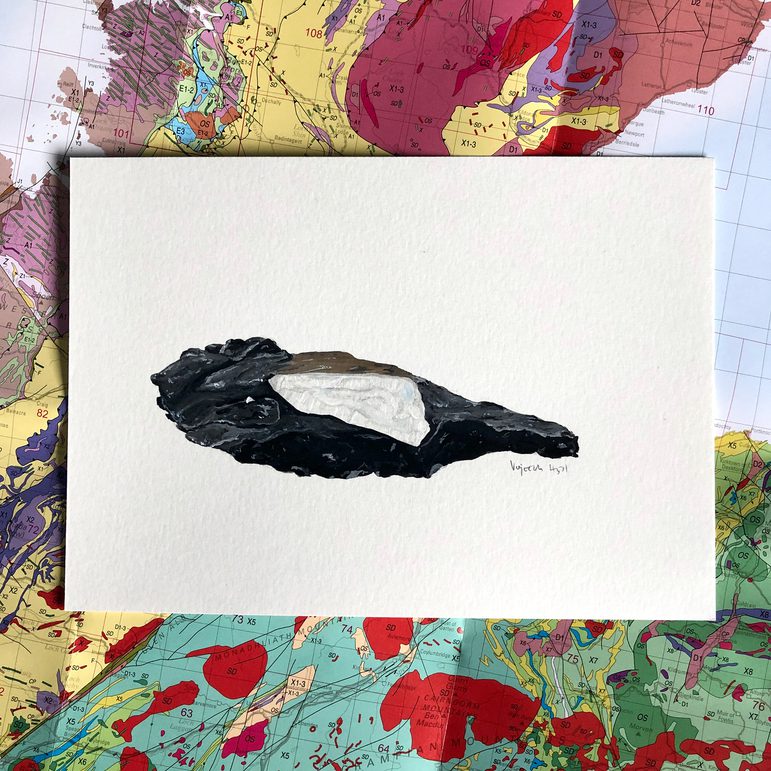 An illustration of dark grey and white mineral on a white piece of paper. The illustration is photographed against a geological map of Scotland.