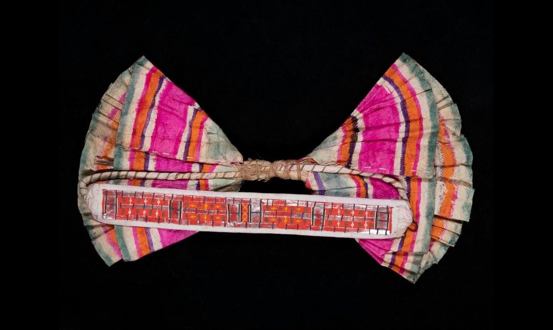 A bow made from pink, white, orange, and green striped fabric