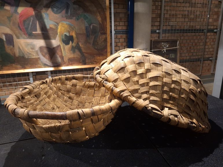 2 round, domed baskets woven out of straw.