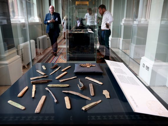 Visitors looking at objects from the Galloway Hoard in a glass museum case