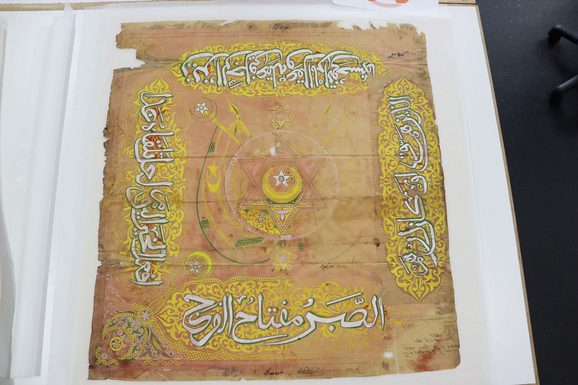 The same piece of paper is laid out on a white sheet after undergoing treatment